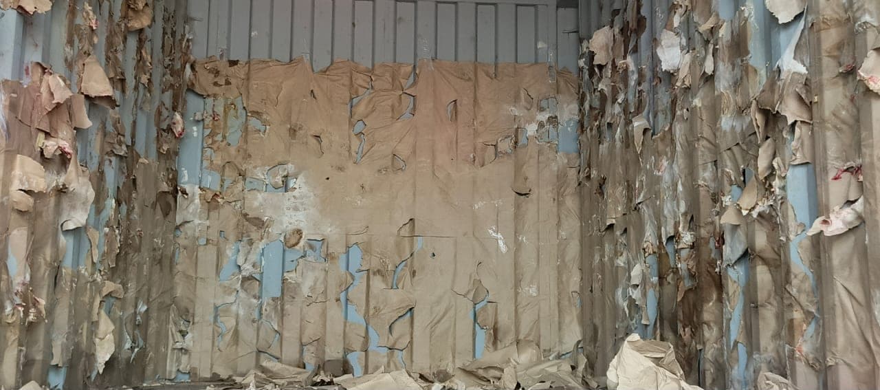 Torn container lining showing visible cargo damage