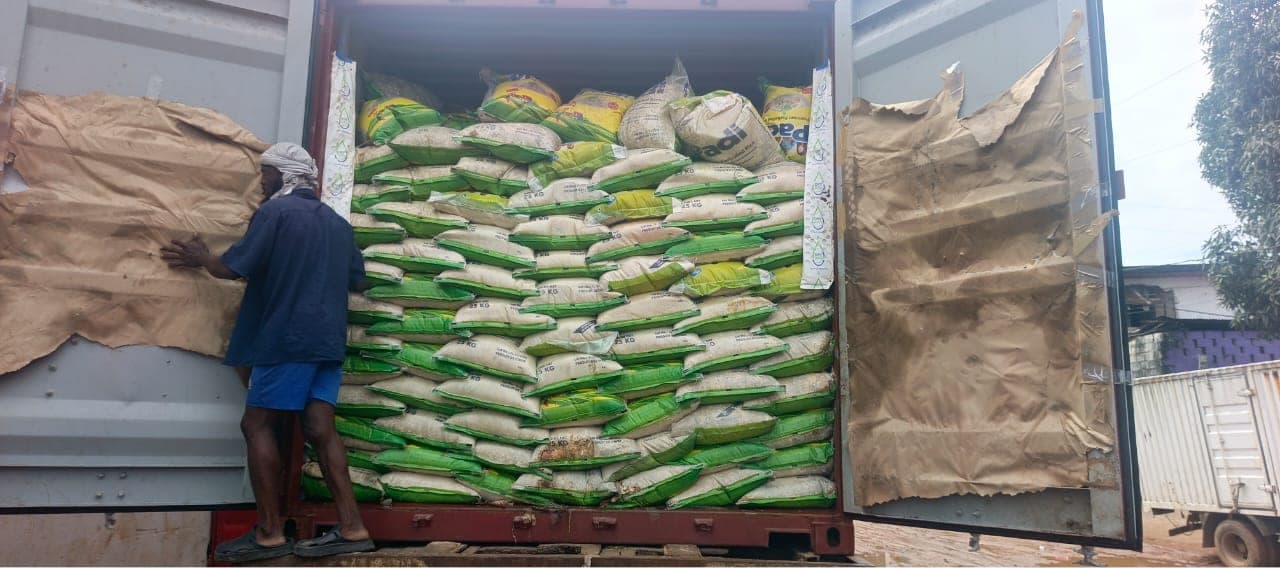 Worker loading bagged rice cargo into a shipping container