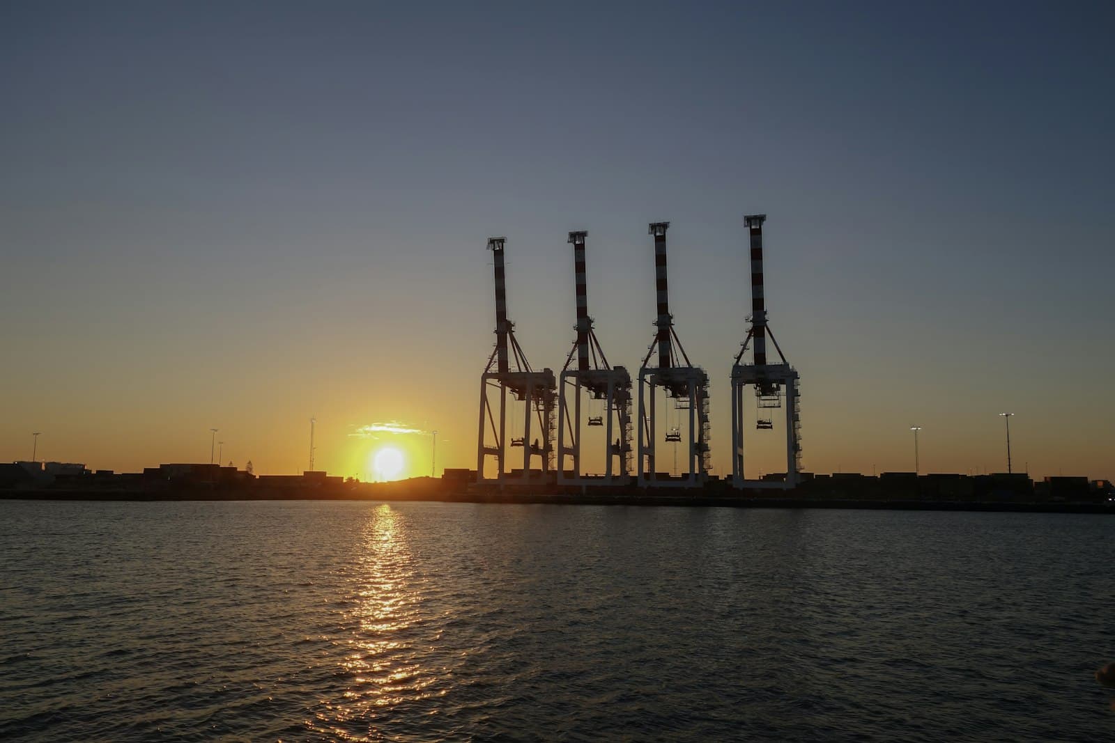 Container terminal gantry cranes silhouetted at sunset