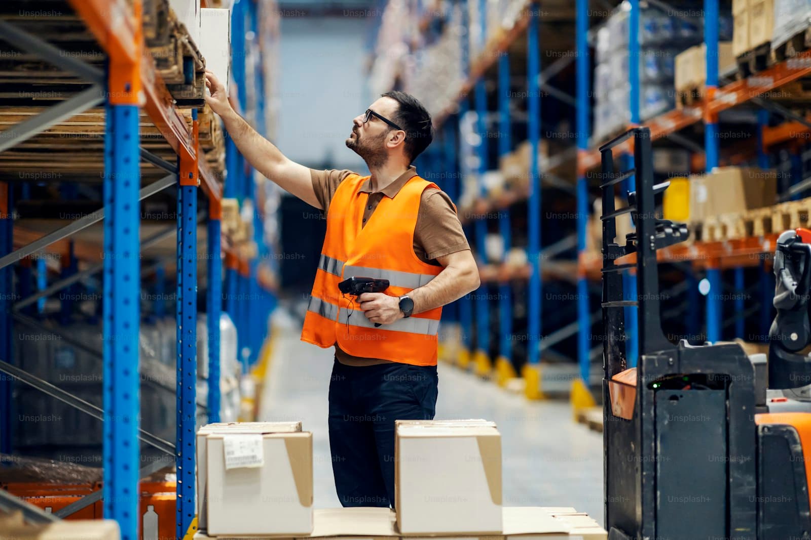 Warehouse worker checking goods on storage shelving